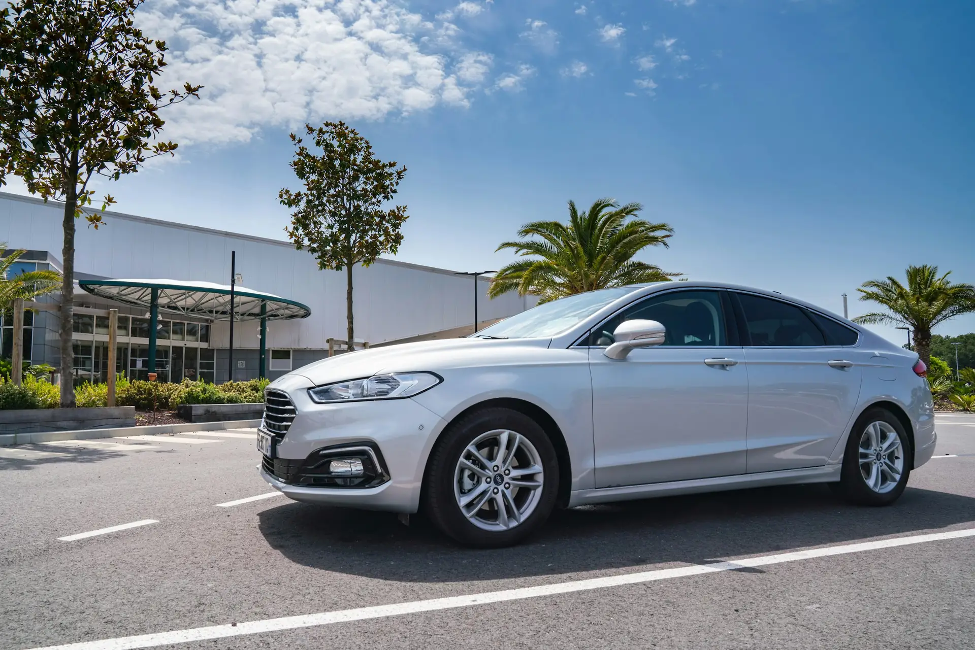 Silver sedan waiting outside a terminal building